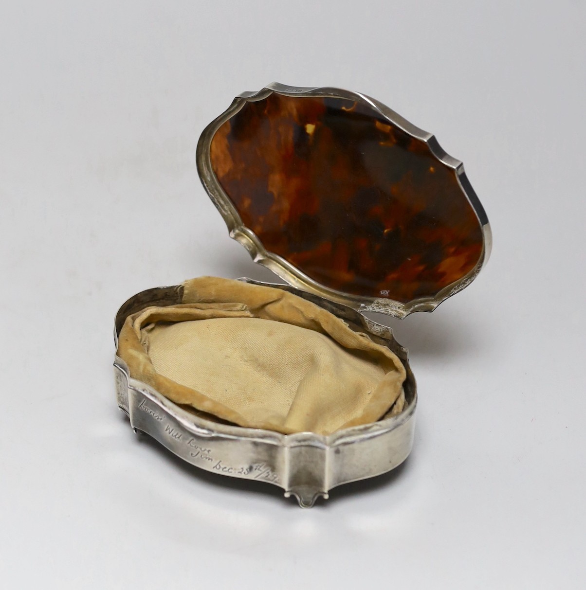 A George V silver and tortoiseshell mounted shaped oval trinket box, Birmingham, 1929, with engraved inscription, 12.6cm.